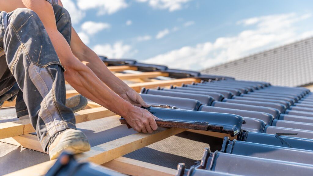 men applying tiles on roof