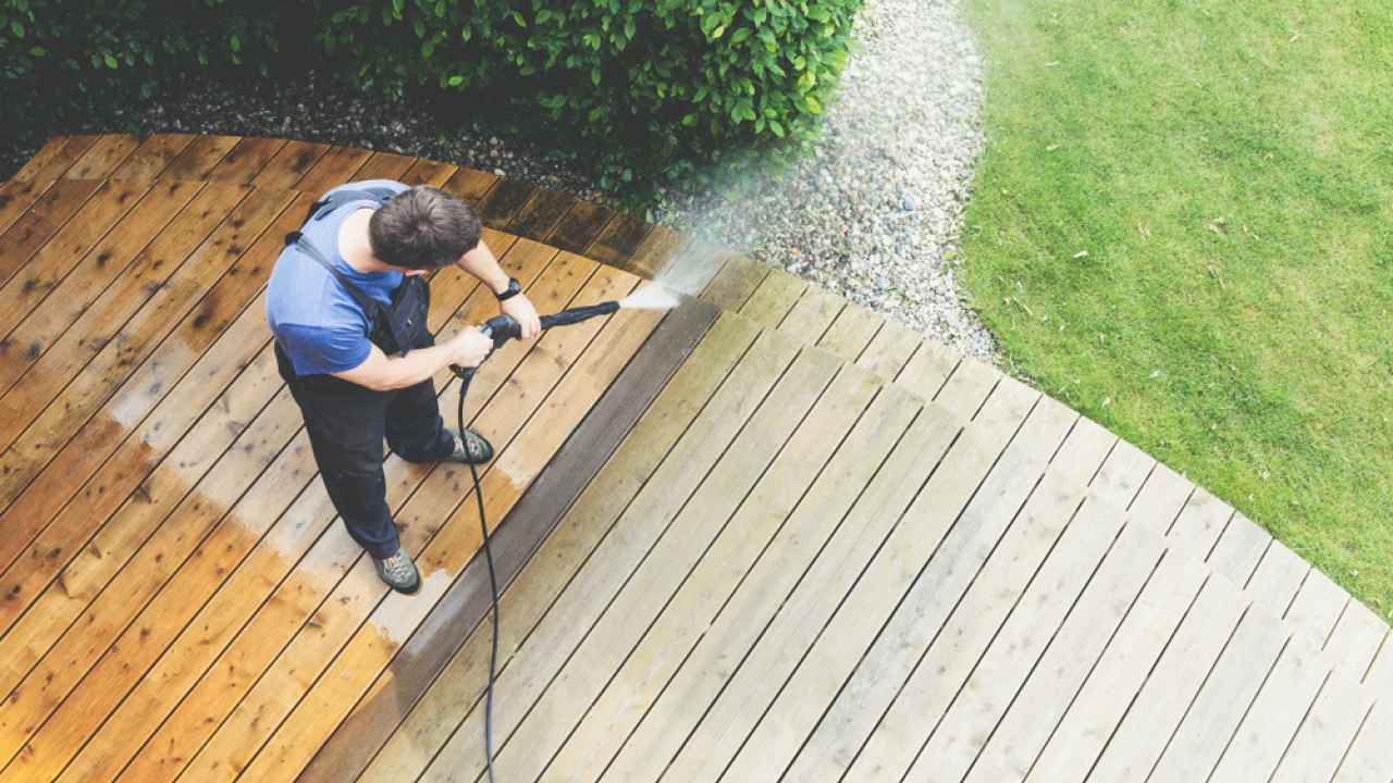 men clean the home surface with pressure washer machine