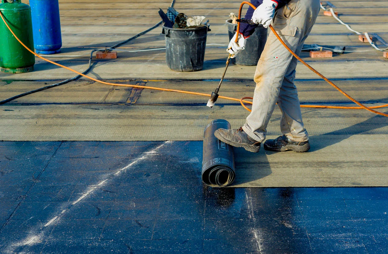 worker install black sheet with heat gun on roof